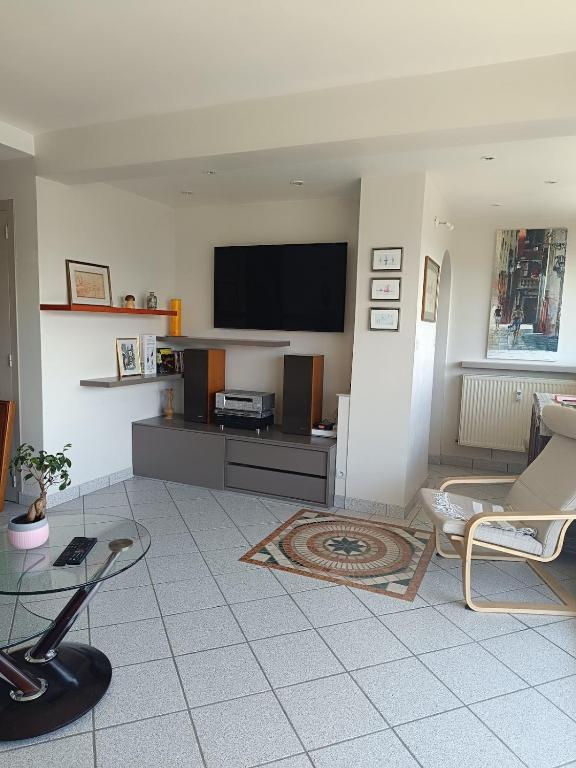 un salon avec une télévision à écran plat sur un mur dans l'établissement La Tour Gambetta T3 Vue lac, à Annecy