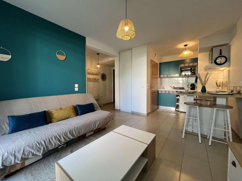 un salon avec un canapé et une cuisine dans l'établissement Appartement T2 - LA ROCHELLE - LR910-012, à Fontenille-Saint-Martin-d'Entraigues