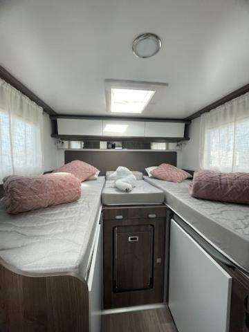 a small room with two benches with pink pillows at Autocaravana la brujula in Blanes