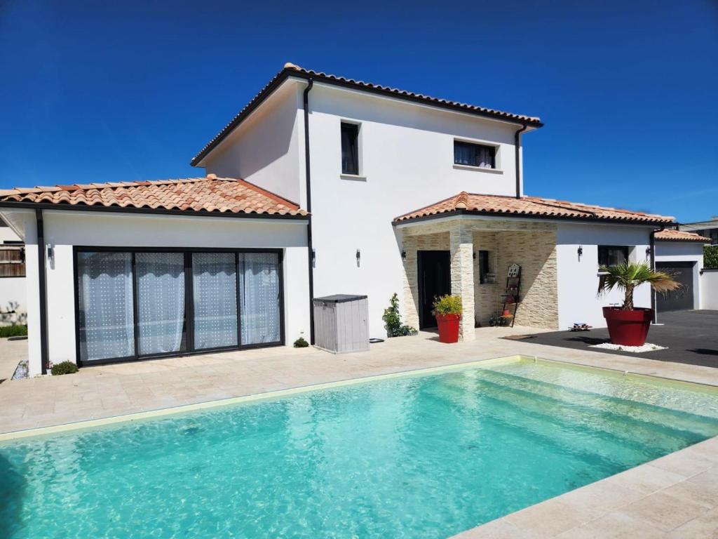 une villa avec piscine devant une maison dans l'établissement Villa avec piscine jacuzzi et sauna, à Saint-André-de-Cubzac