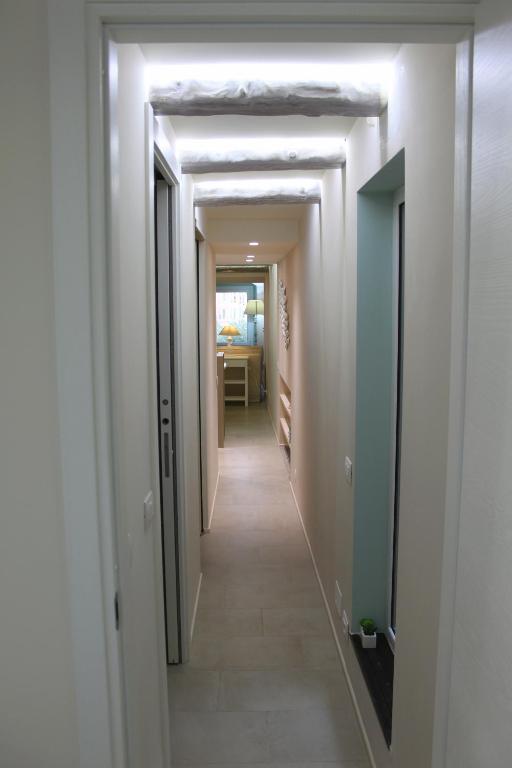 a hallway with white walls and a long hallway with white ceilings at Clara's House in Portofino