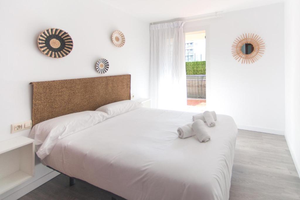 a white bedroom with a bed with a stuffed animal on it at WELCS APARTAMENTO 204 PDA junto al mar in L'Estartit