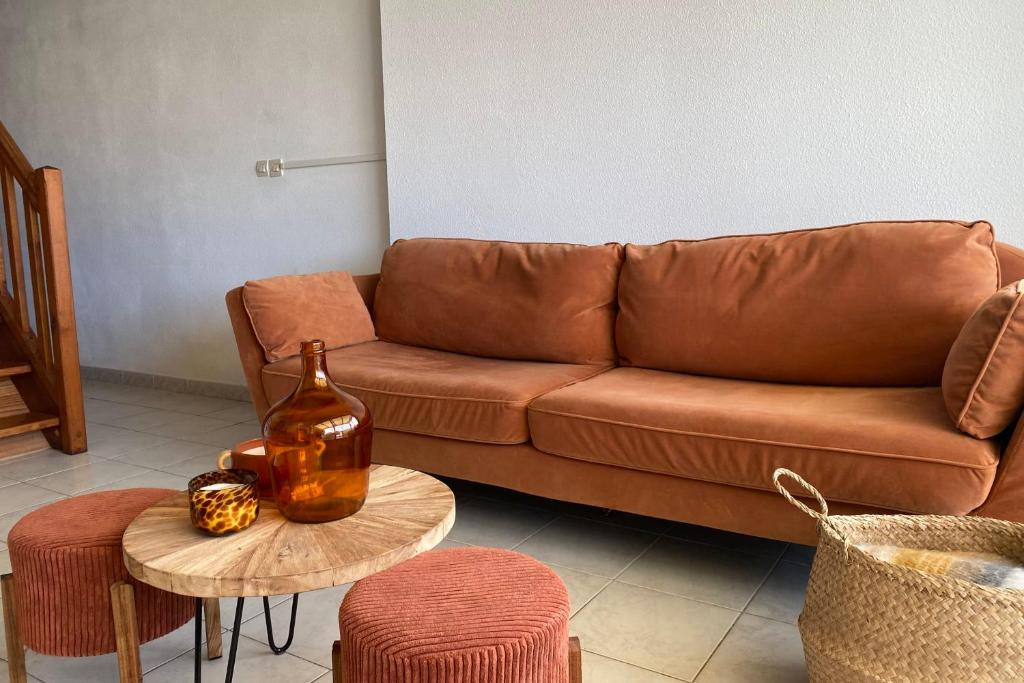 un salon avec un canapé marron et une table dans l'établissement Between port and beach the best of both worlds, à Frontignan