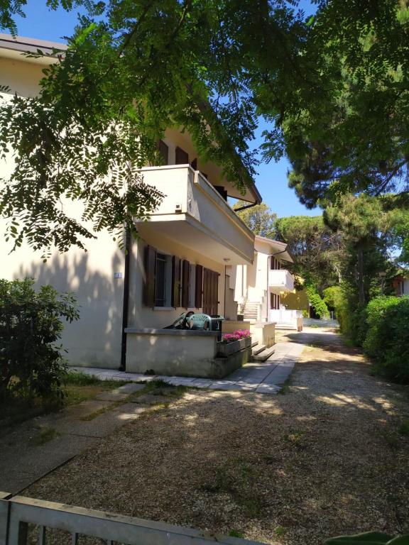 a white house with a tree in front of it at Cacciatore in Rosolina