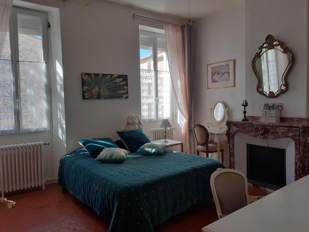 - une chambre avec un lit doté d'oreillers bleus et d'une cheminée dans l'établissement Grande chambre avec parties communes en bord de mer, à Port-la-Nouvelle
