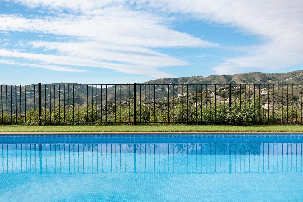 a swimming pool in front of a fence at Casa Ilusión in Frigiliana