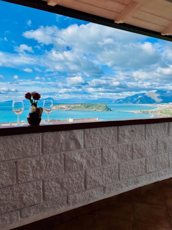a window with wine glasses and a view of the ocean at Apartment San Nicola Arcella in Saracena