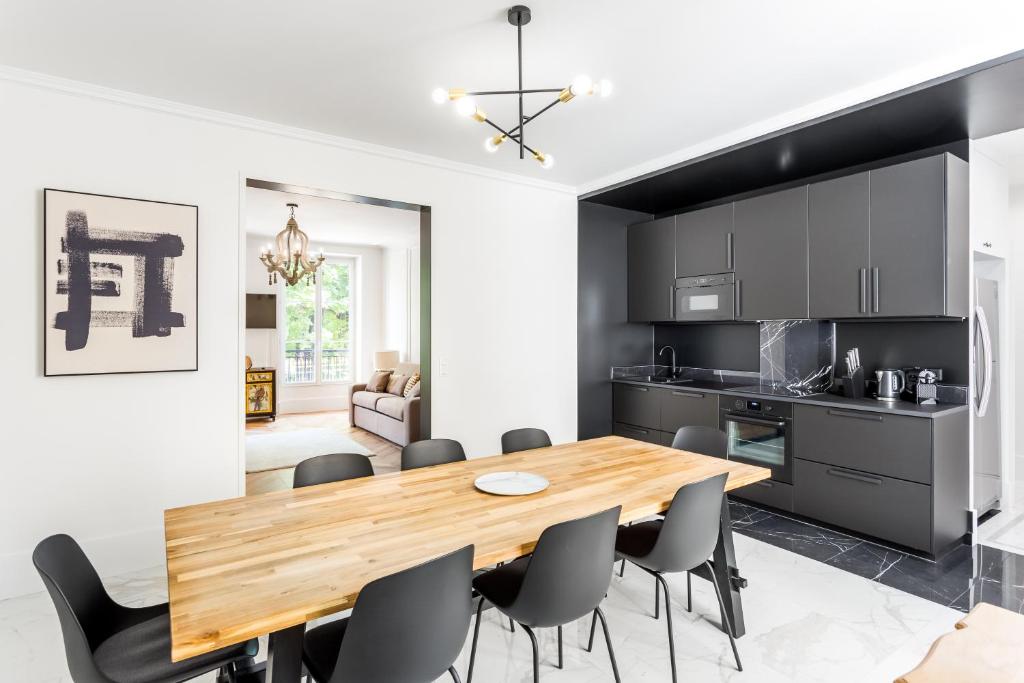 une cuisine et une salle à manger avec une table et des chaises en bois dans l'établissement The black Swan, à Paris