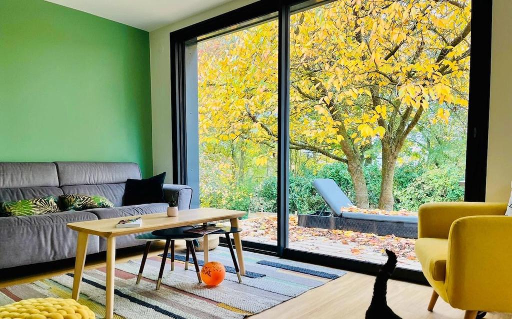 un salon avec un canapé et une grande fenêtre dans l'établissement Maison Familiale tout confort, à Mouen