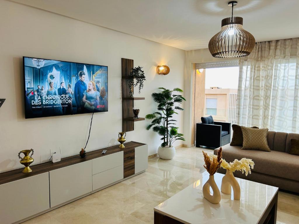 TV a/nebo společenská místnost v ubytování Azure Nest - Sea View Duplex with Golf and Pool Access in Taghazout Bay