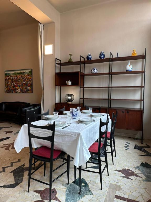 a dining room table with chairs and a white table cloth at casa greta in Viareggio