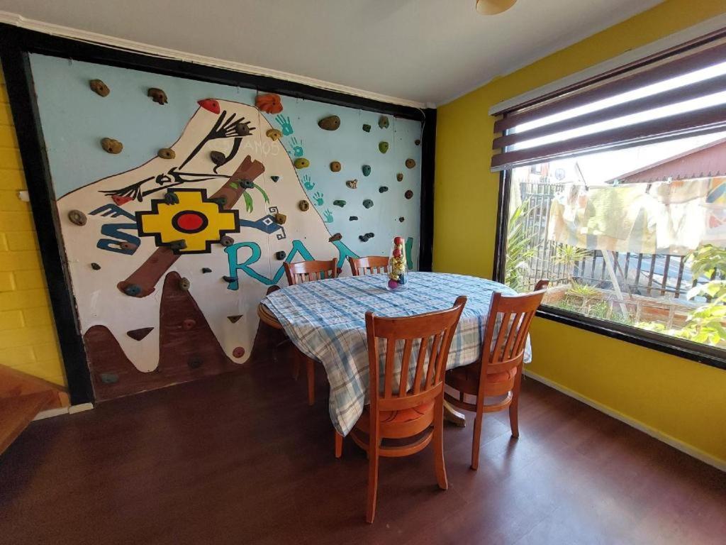 ein Esszimmer mit Tisch und Stühlen und einem großen Fenster in der Unterkunft Cómoda casa familiar in Valdivia