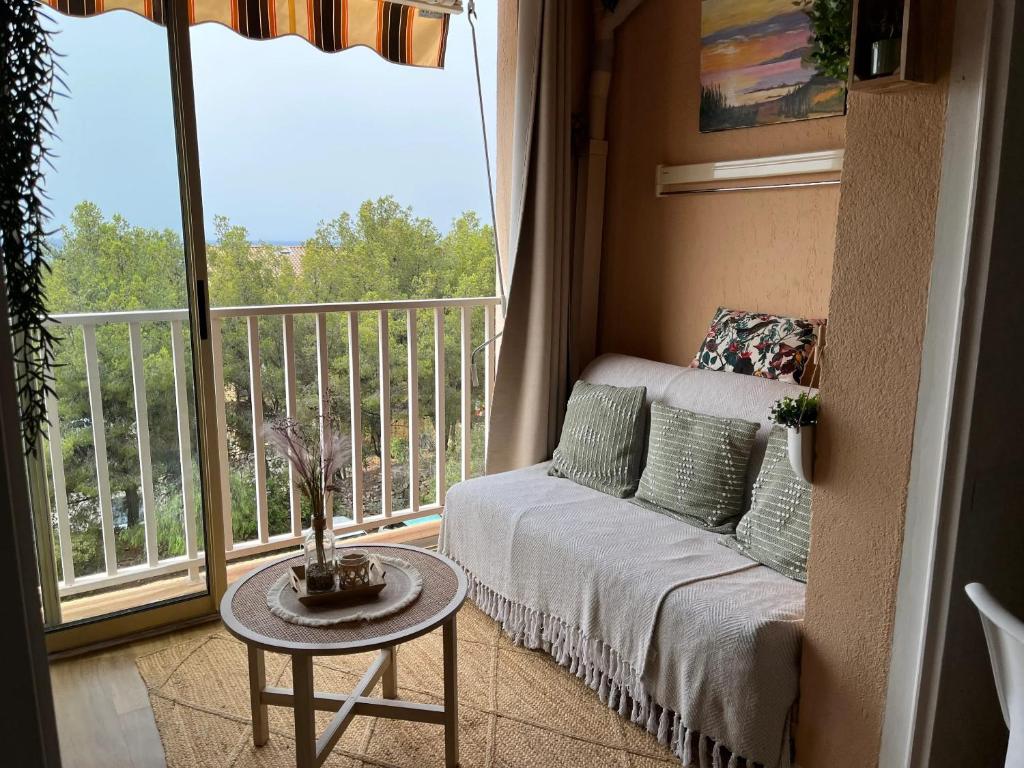 ein Wohnzimmer mit Couch und Balkon in der Unterkunft Appartement charmant à Bandol 30 m² avec vue sur la mer. in Bandol