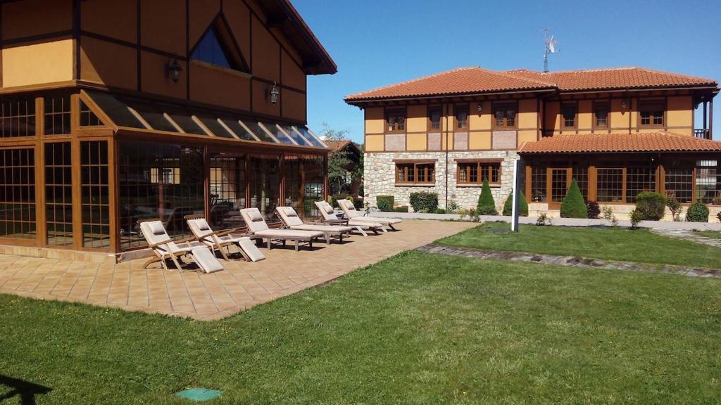 a patio with lounge chairs and a building at Casa las Vacas in Cervera de Pisuerga