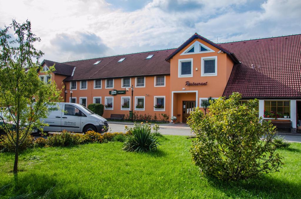 un edificio con un coche aparcado delante de él en Hotel U Jezera, en Velký Osek