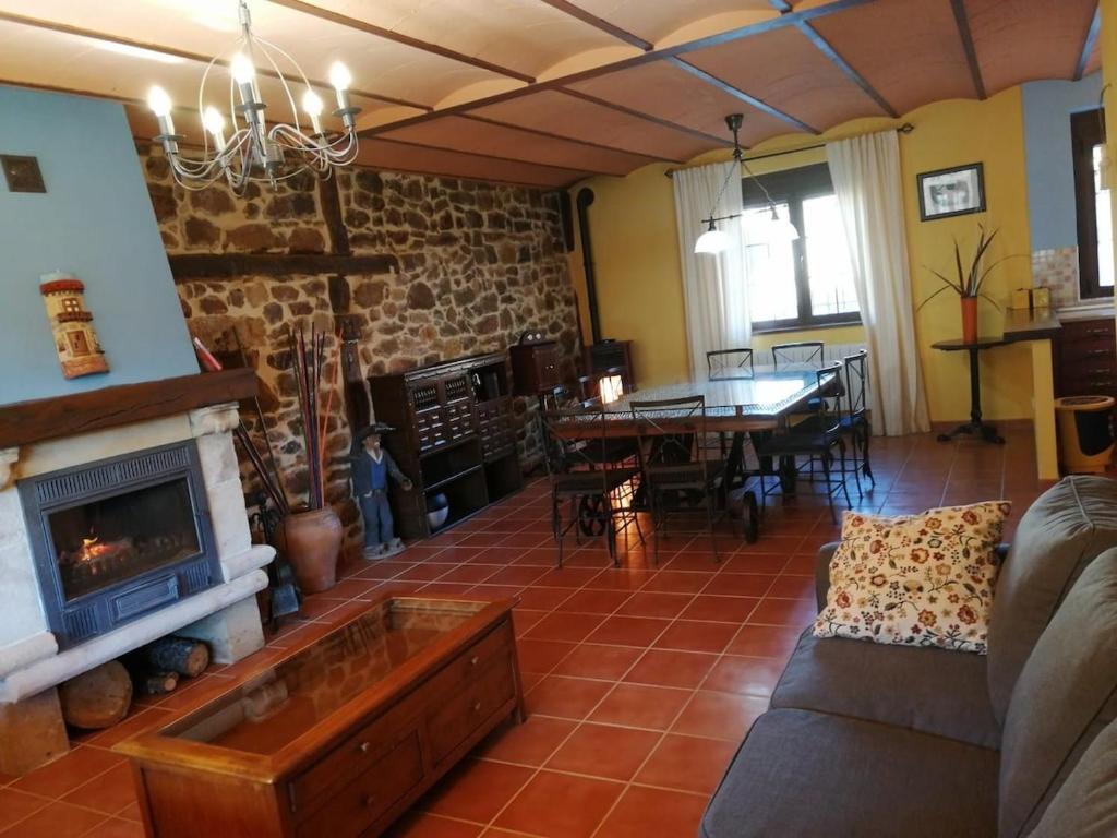 ein Wohnzimmer mit Couch und Kamin in der Unterkunft Casa rural San Felices in San Felices de Castillería