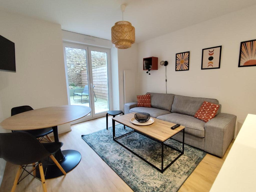 un salon avec un canapé et une table dans l'établissement Beau et calme T1 avec Terrasse au coeur de Kerinou, à Brest