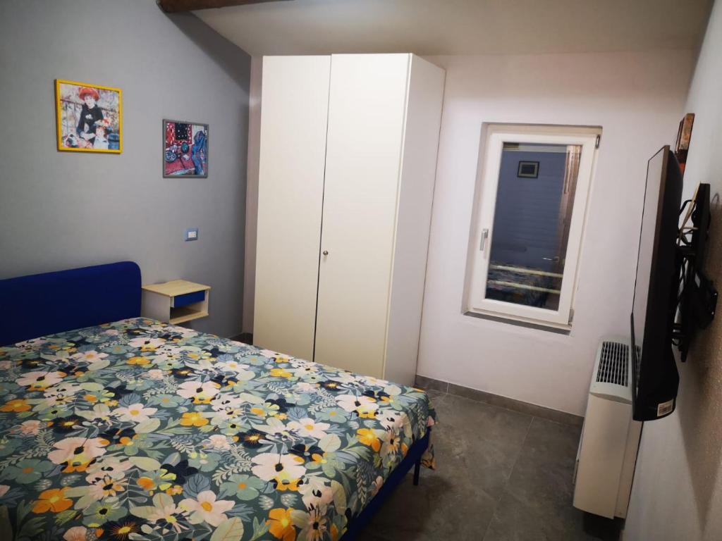 a bedroom with a bed and a cabinet and a window at Casa LaSer in Cotignola