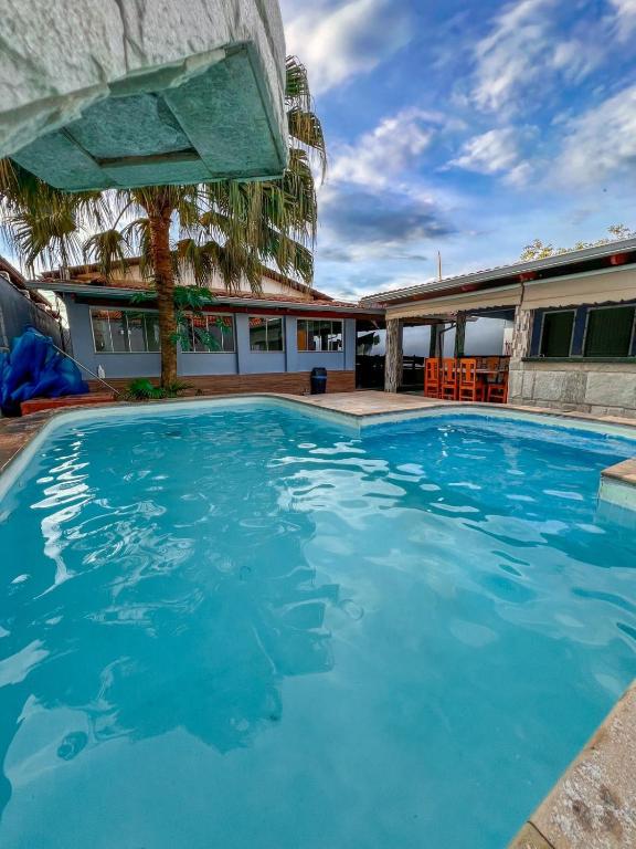 a swimming pool with blue water in front of a building at kasada Nanda in Pirenópolis