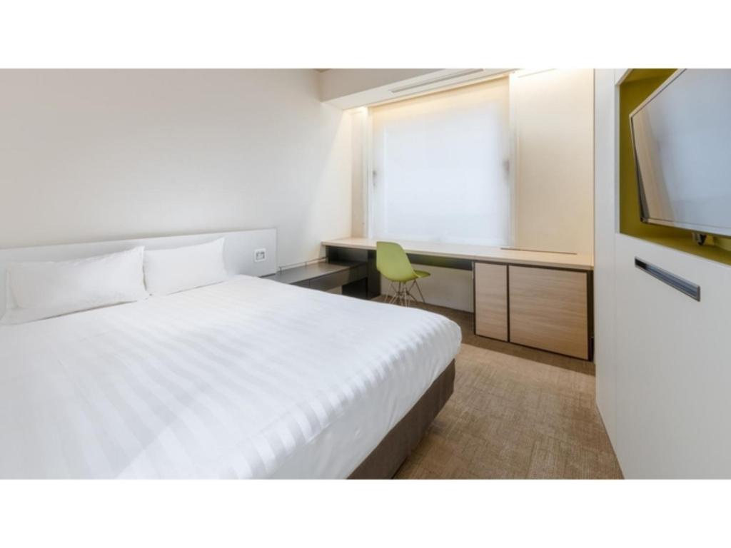 a bedroom with a bed and a desk and a television at The OneFive Sendai - Vacation STAY 35241v in Sendai