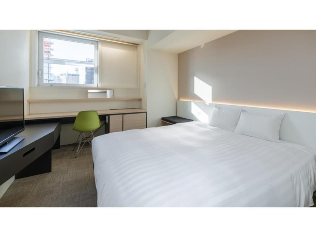 a hotel room with a white bed and a desk at The OneFive Sendai - Vacation STAY 35252v in Sendai