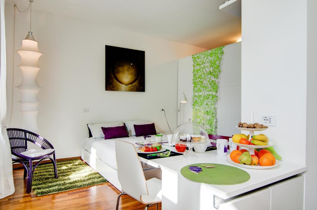 ein weißes Wohnzimmer mit einem Tisch und einem Bett in der Unterkunft Porta Garibaldi in Mailand