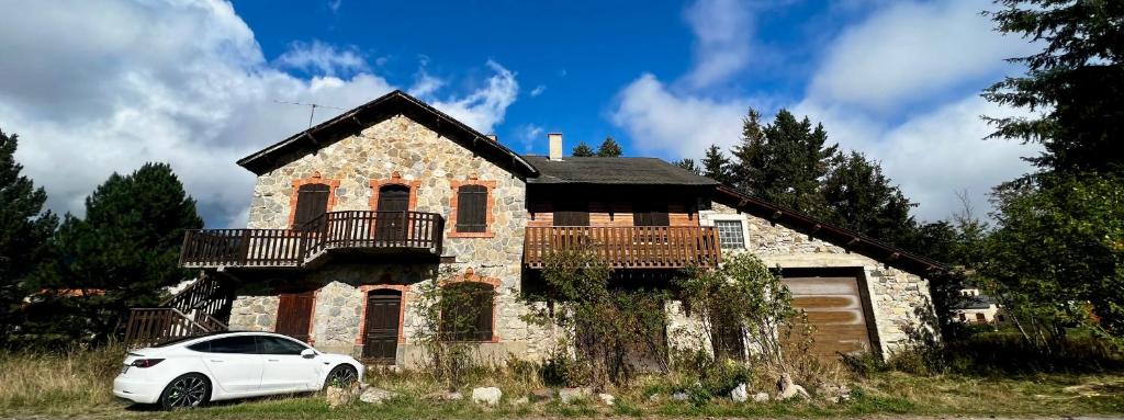 une voiture blanche garée devant une maison dans l'établissement Maison de Margaux - Montagne, à Puyvalador