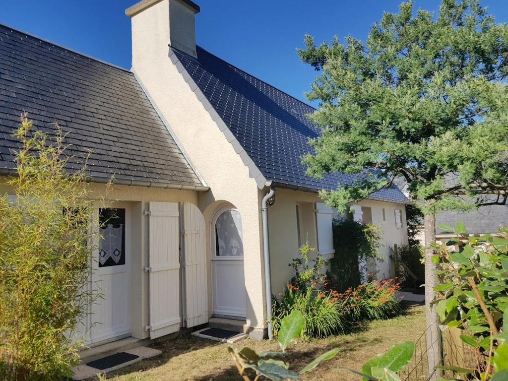 une maison avec un garage et un arbre dans l'établissement Maison des dunes Echappée Belle, à Barneville-Carteret