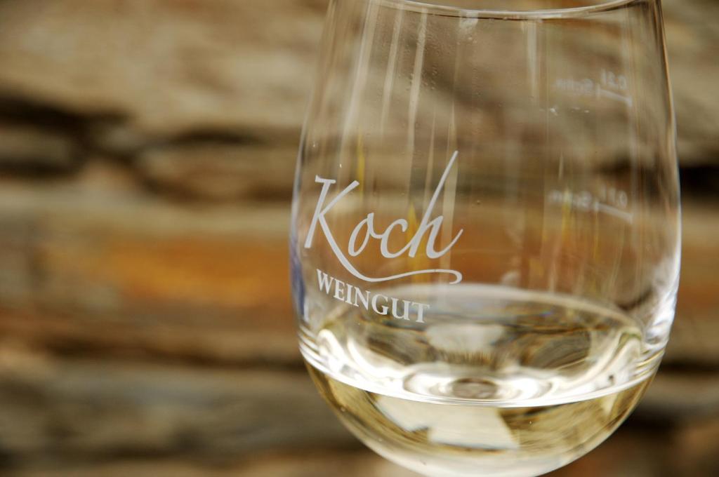 a glass of white wine sitting on a table at Weingut Koch in Neumagen-Dhron