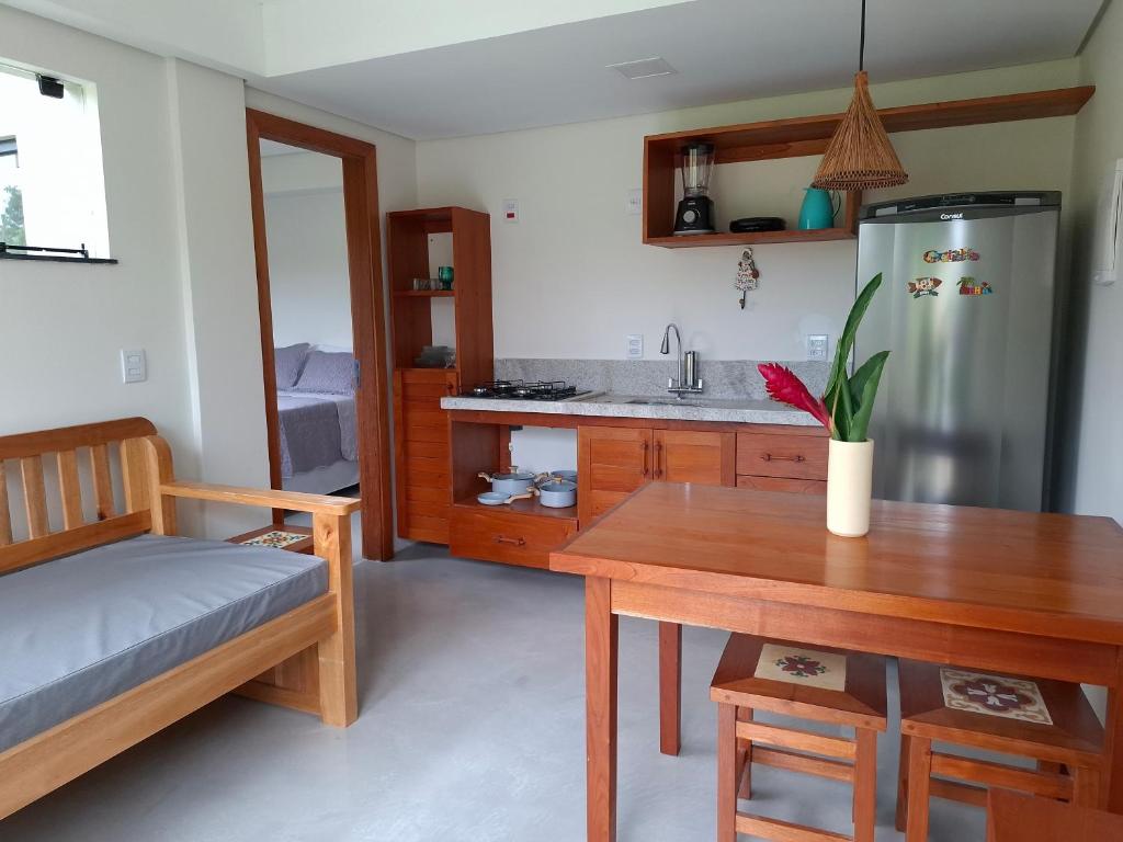 a kitchen with a wooden table and a refrigerator at Casa Liz in Itacaré