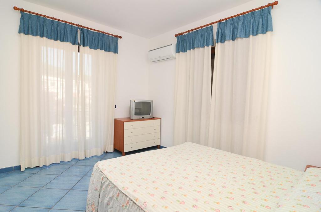 a bedroom with a bed and a tv on a dresser at Residence Polito in Ischia