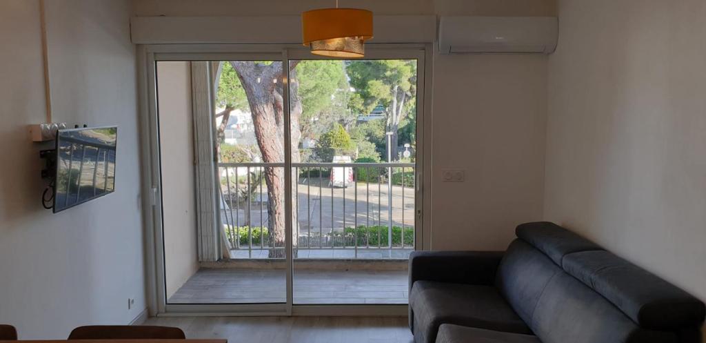 un salon avec un canapé et une grande fenêtre dans l'établissement Joli studio au Ponant avec parking, à La Grande Motte