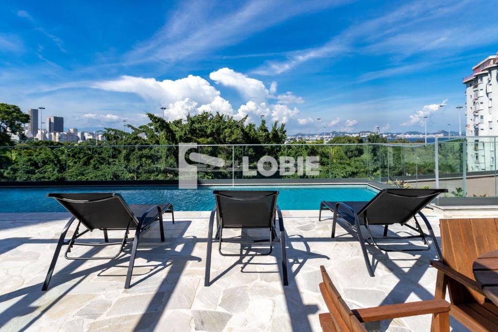 Hotel Lobie Gloria Del'Art, a patio with chairs and a swimming pool at Lobie Gloria Del'Art in Rio de Janeiro