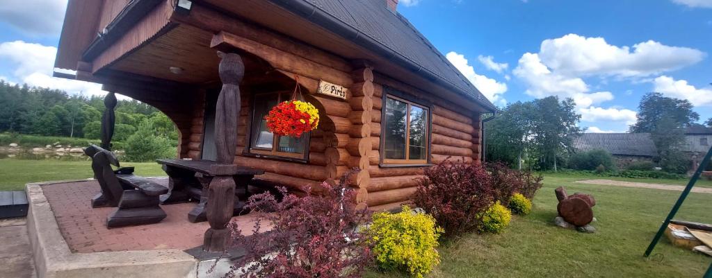 una cabaña de madera con una corona de flores. en Sauna&Relax, en Sakstagals