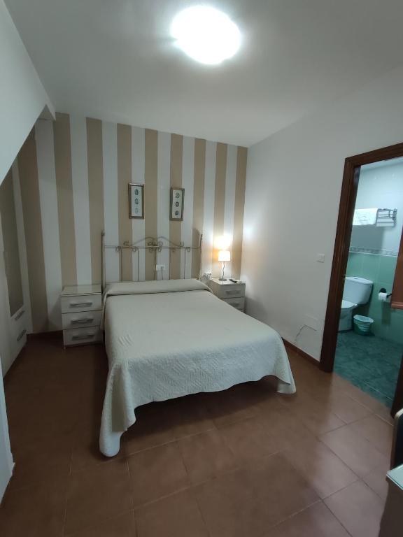 Postel nebo postele na pokoji v ubytování Pensión y apartamentos El Taxi
