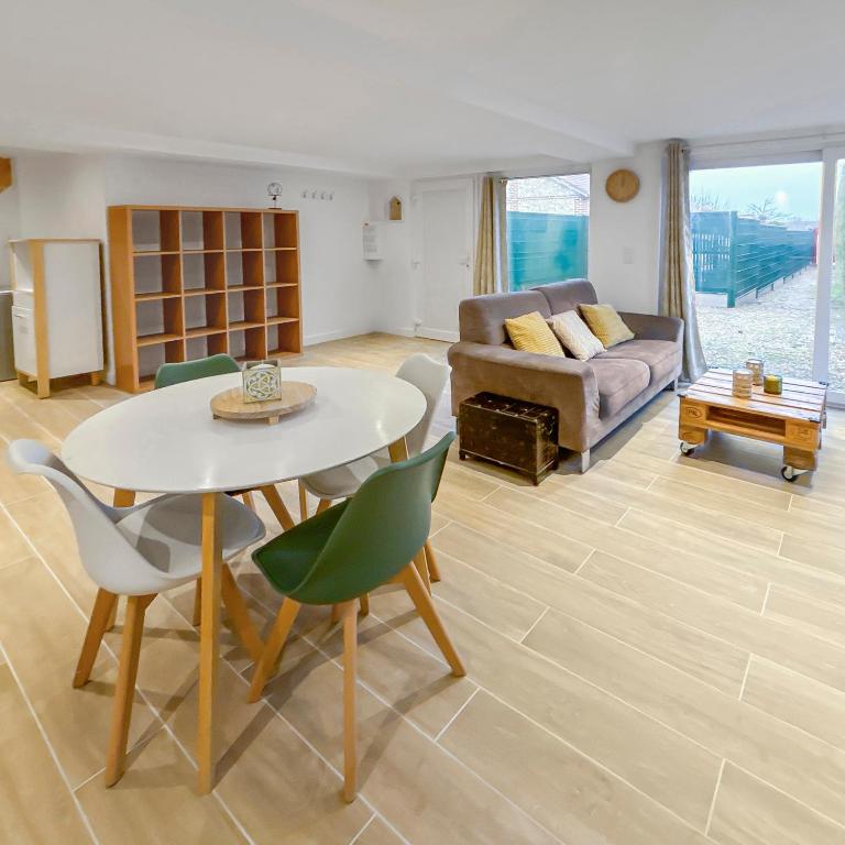 un salon avec une table, des chaises et un canapé dans l'établissement Maison cosy rénovée et lumineuse, à Pont-de-lʼArche
