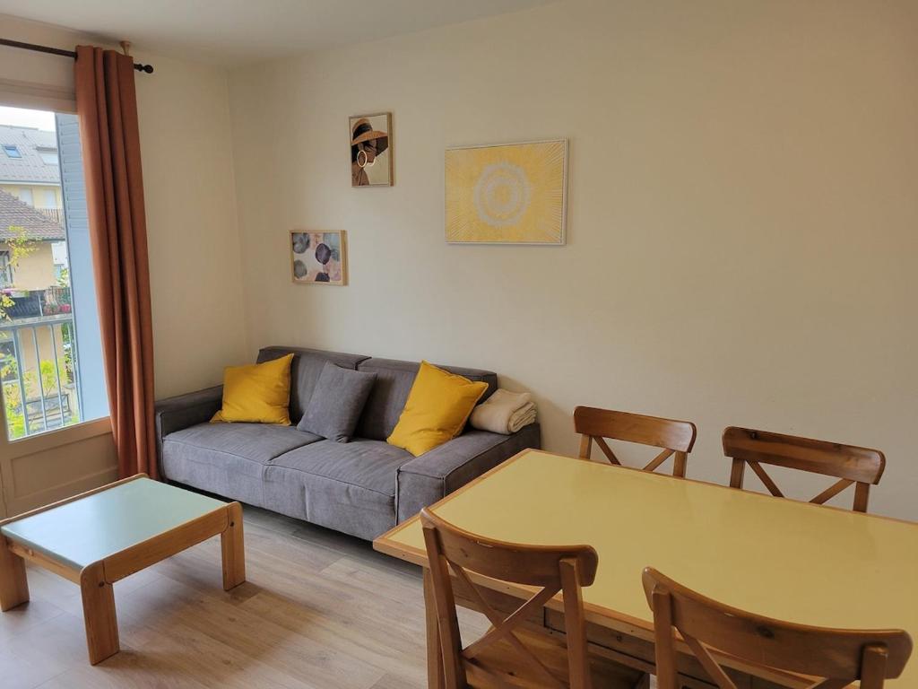 un salon avec un canapé et une table dans l'établissement Les Vallées, à Thonon-les-Bains