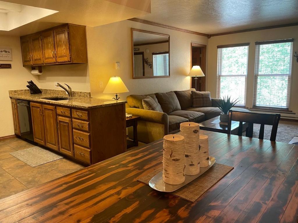 a kitchen and living room with a couch and a table at Snowed Inn in Brian Head