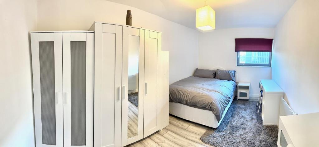 a bedroom with a bed and a large white cabinet at Large Double Room in Cardiff City Centre, Room Only with Own Bathroom, HOST LIVES ON SITE in Cardiff