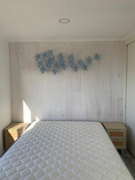 una camera da letto con un grande letto bianco in una stanza di Tiny cabaña en playa hermosa Pichilemu a Pichilemu