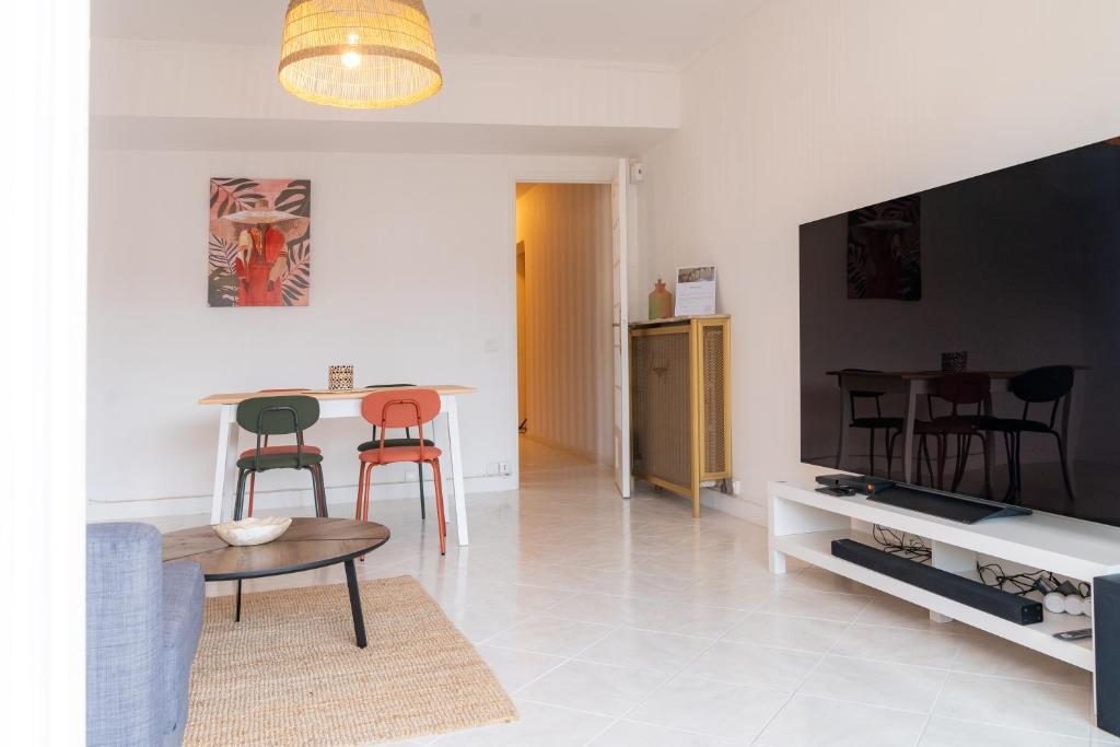 - un salon avec une table, des chaises et une télévision dans l'établissement 2 pièces - 4 personnes - Entièrement équipé et idéalement situé proche toutes commodités, à Menton