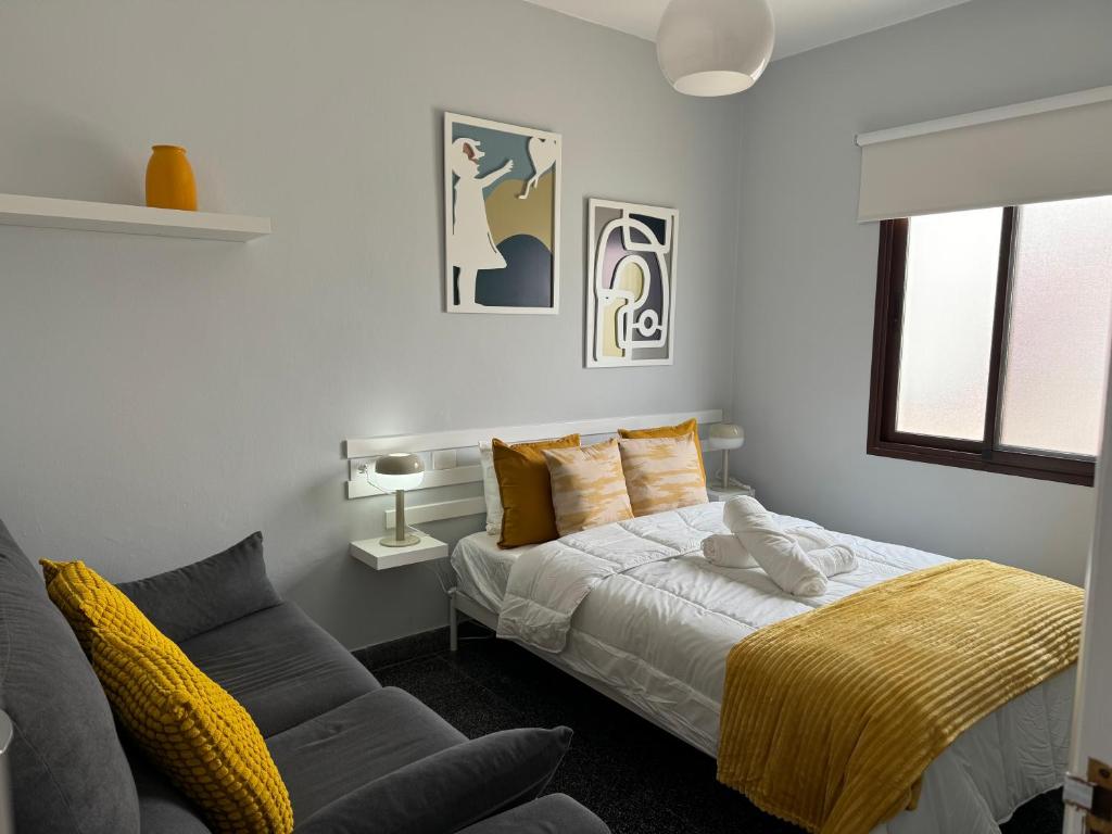 un dormitorio con una cama y un sofá en Jobeal City, en Santa Cruz de la Palma