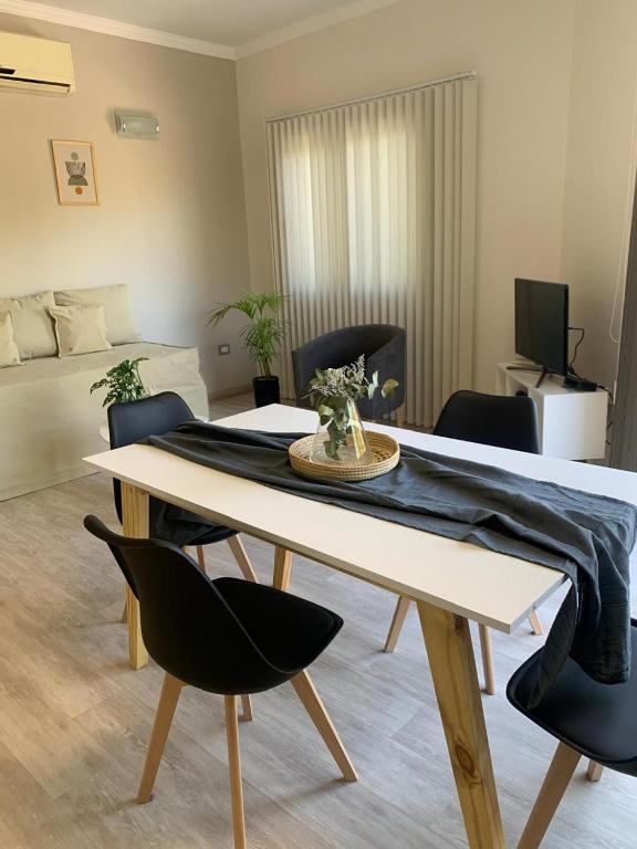 Una sala de estar con una mesa de comedor y sillas. en Laprida Suites 1 San Juan, en San Juan