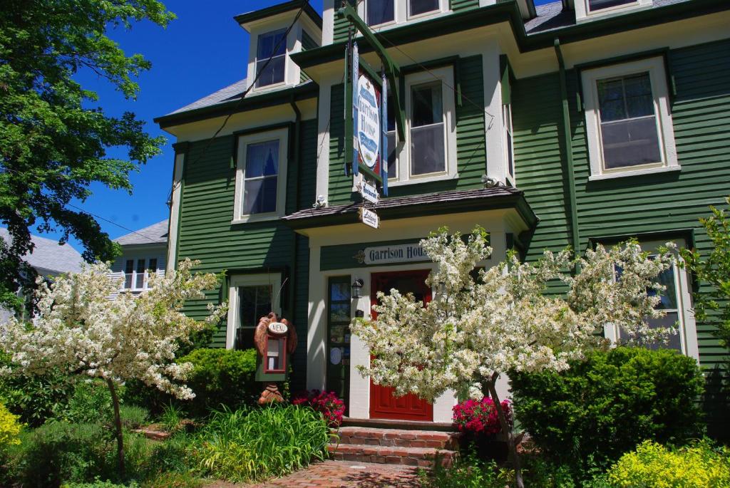 a green house with a red door at The Garrison House Inn in Annapolis Royal