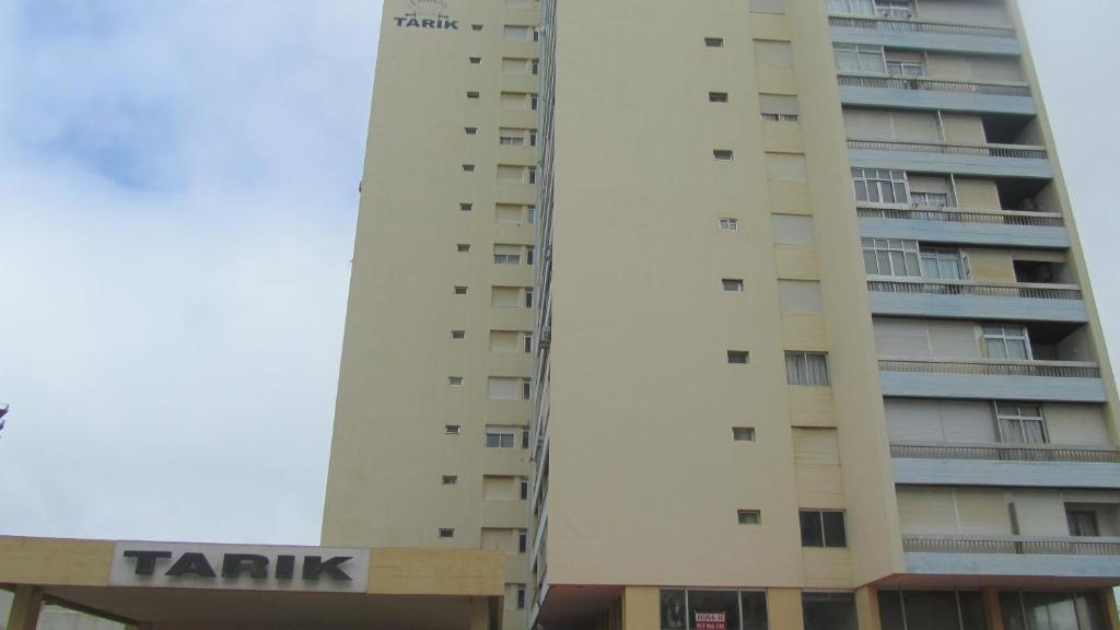 ポルティマンにあるTarik Apartmentの看板が目の前にある高層ビル