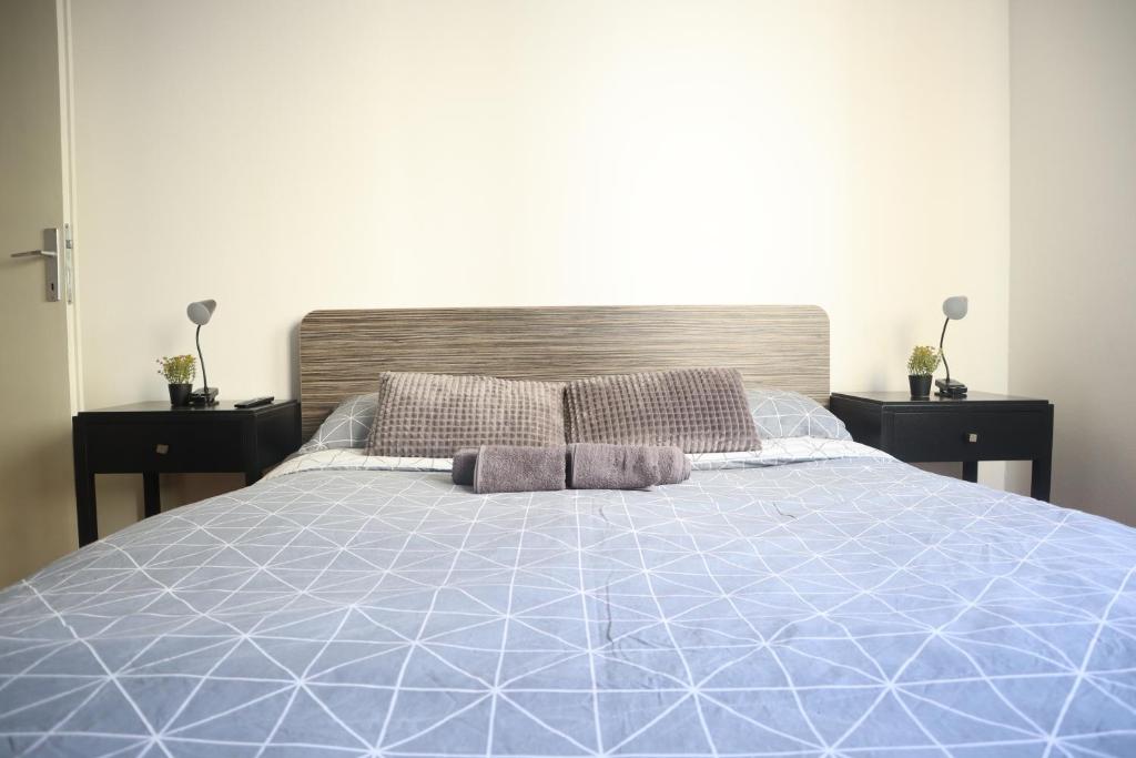 1 cama con edredón azul y 2 almohadas en Štadler's Corner, en Sarajevo