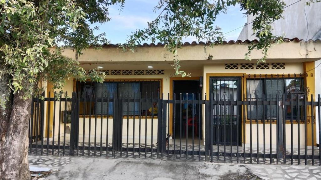 a yellow building with a black fence in front of it at Casa Candido, cerca al CC Único y al Aeropuerto in Neiva