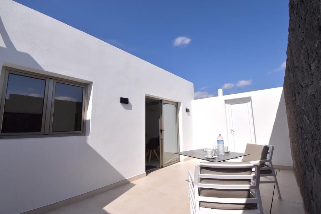 a dining room with white walls and a table and chairs at Nicole Home in Playa Blanca