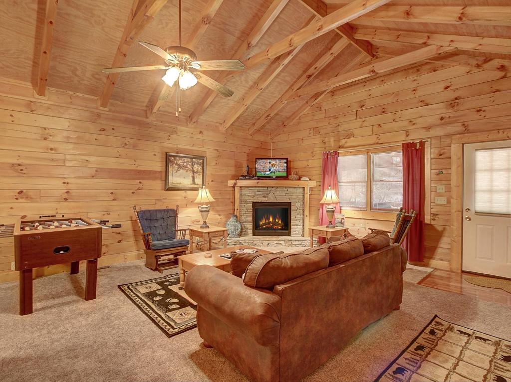 un salon avec un canapé et une cheminée dans l'établissement 1BR log cabin- cozy, hot tub, in Gatlinburg, à Gatlinburg