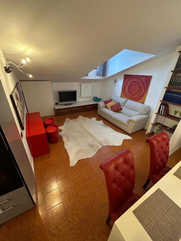 a living room with a white couch and red chairs at Residenza Il Carducci in Bergamo